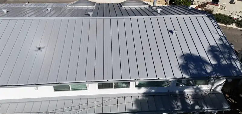 Silver standing seam metal roof with two dome skylights, seen from above